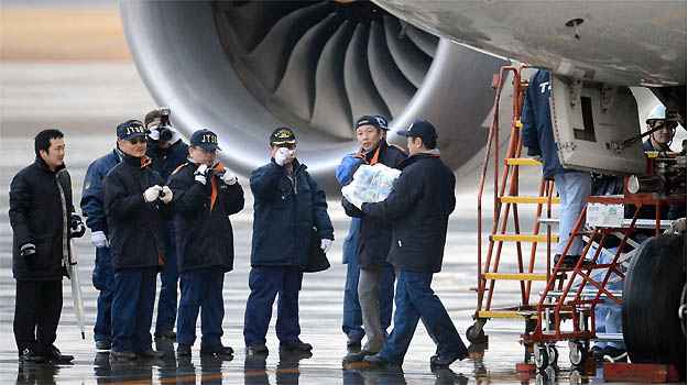 Investigadores japoneses trabalham em avi�o da ANA (Reuters)