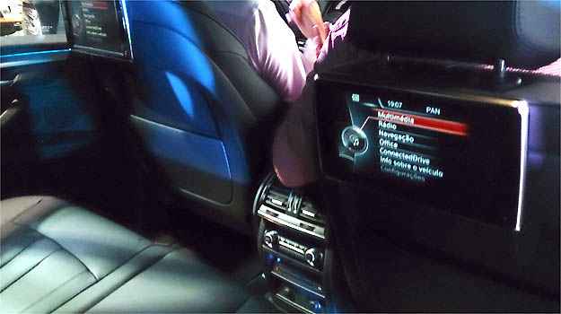 Passageiros que viajam no banco traseiro contam com tele multifuncional de acesso individual Passageiros que viajam no banco traseiro contam com tele multifuncional de acesso individual